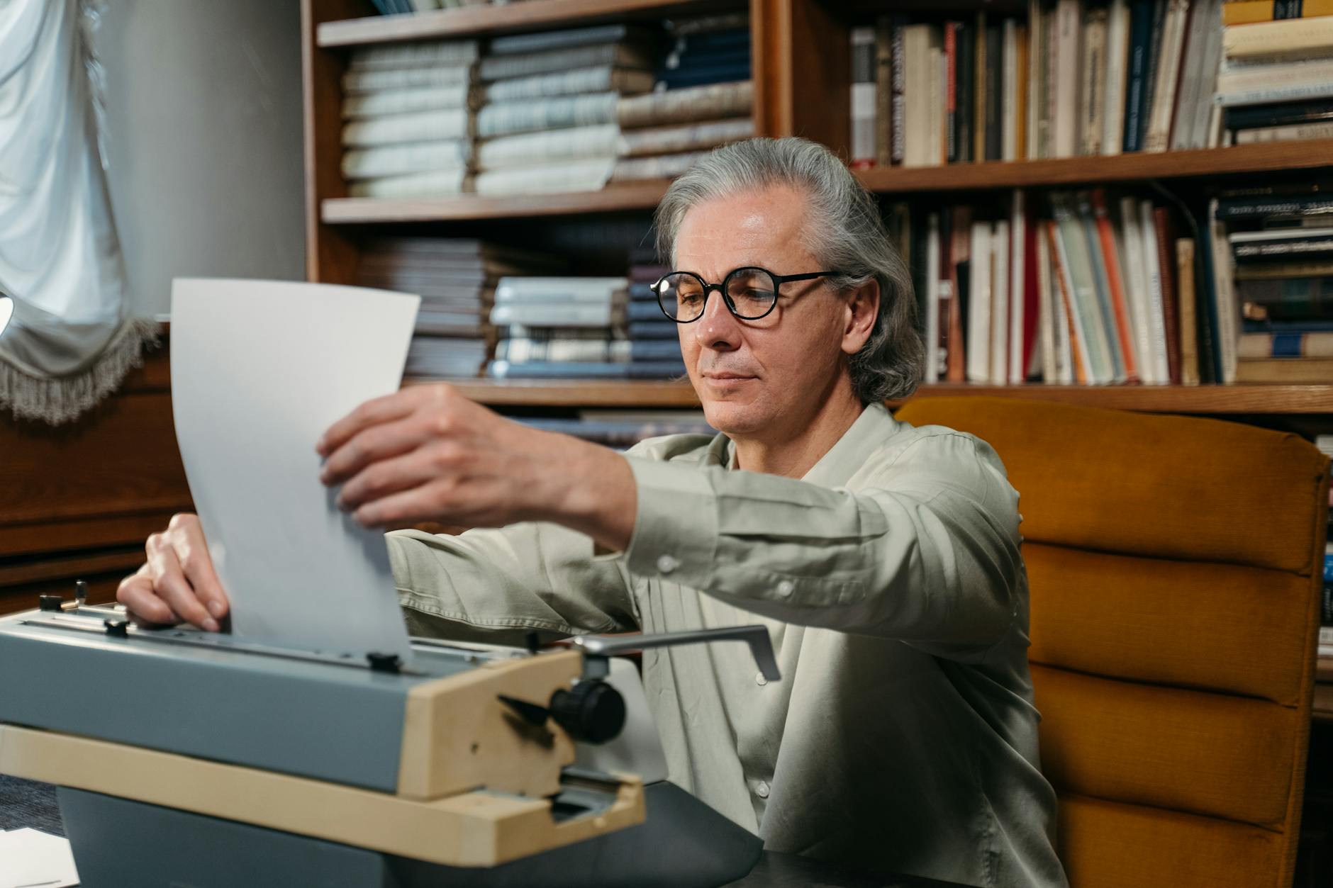 Author at a vintage typewriter in a library